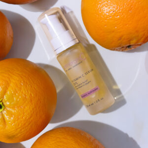 Sentence with Product Name: 20% vitamin C serum surrounded by fresh oranges, suggesting citrus-based skin nourishment.