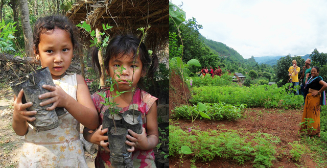 Two young girls hold small tree saplings in a rural setting, with a backdrop of lush greenery and a community engaged in agricultural activities.