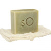 A Scientific Organics Facial Bar resting on a natural fiber soap dish against a white background.