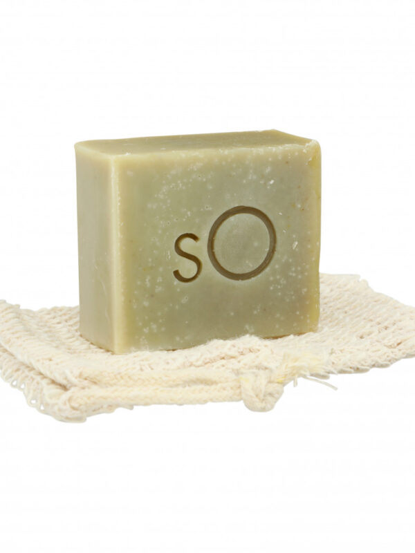 A Scientific Organics Facial Bar resting on a natural fiber soap dish against a white background.