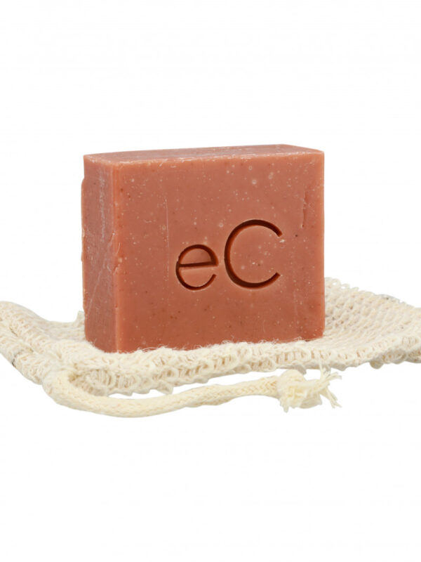 A Signature Facial Bar with the imprint "ec" resting on a natural fiber exfoliating pad, set against a white background.