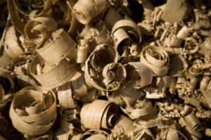 Close-up of golden wood shavings curled and scattered, highlighting the beauty in carpentry remnants.