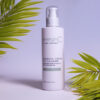 A bottle of emerginc Green Tea Cleanser with green leaves in the background, presented against a soft blue backdrop.