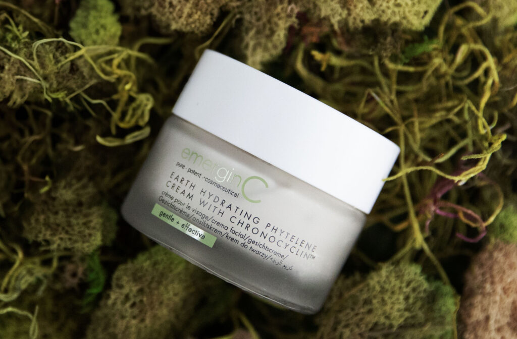 A container of earth hydrating phytelene cream with Chronocyclin™ nestled amidst a bed of vibrant green moss, evoking a sense of natural skincare.