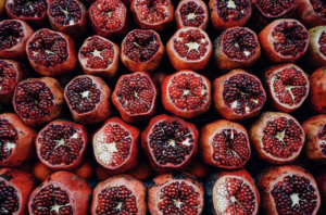A vibrant display of cut pomegranates showcasing their juicy, ruby-red seeds.