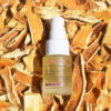 A bottle of EmerginC Vitamin C Eye Serum placed on a bed of dried orange peels, highlighting the citrus-based ingredients of the skincare product.