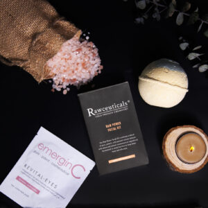 A tranquil and sophisticated At-Home Luxury Spa Kit - Rawceuticals concept with a focus on natural wellness, featuring an assortment of boutique skincare products, himalayan pink salt, a lit candle, and calming botanical accents on a sleek, dark background.