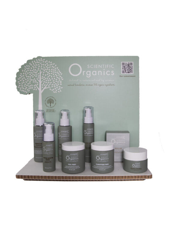 A selection of scientific organics laser cut display skincare products displayed on a shelf with a backdrop featuring branding and a tree graphic.