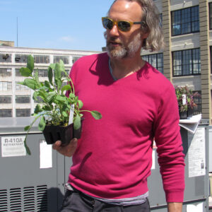 Ian holding plant on rooftop garden