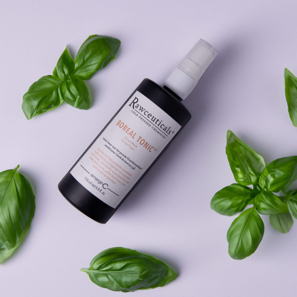 BOREAL TONIC™ surrounded by fresh green basil leaves on a clean, white background.