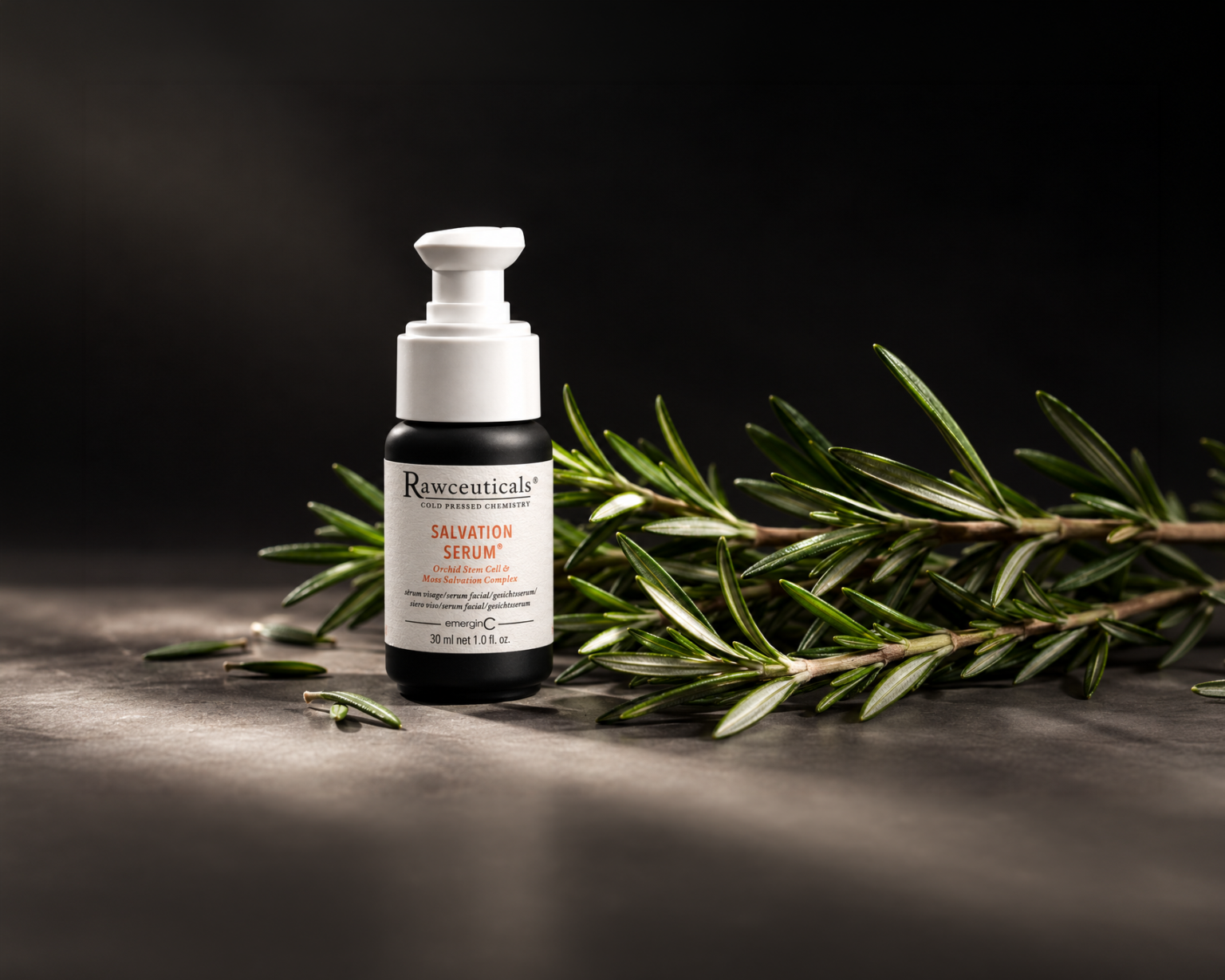 A bottle of Rawceuticals Salvation Serum next to a sprig of rosemary.